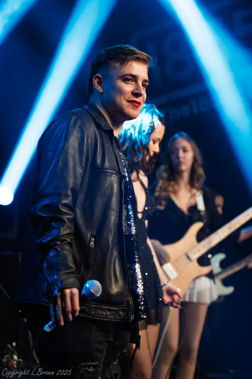 Ollie on stage with his band under blue lights